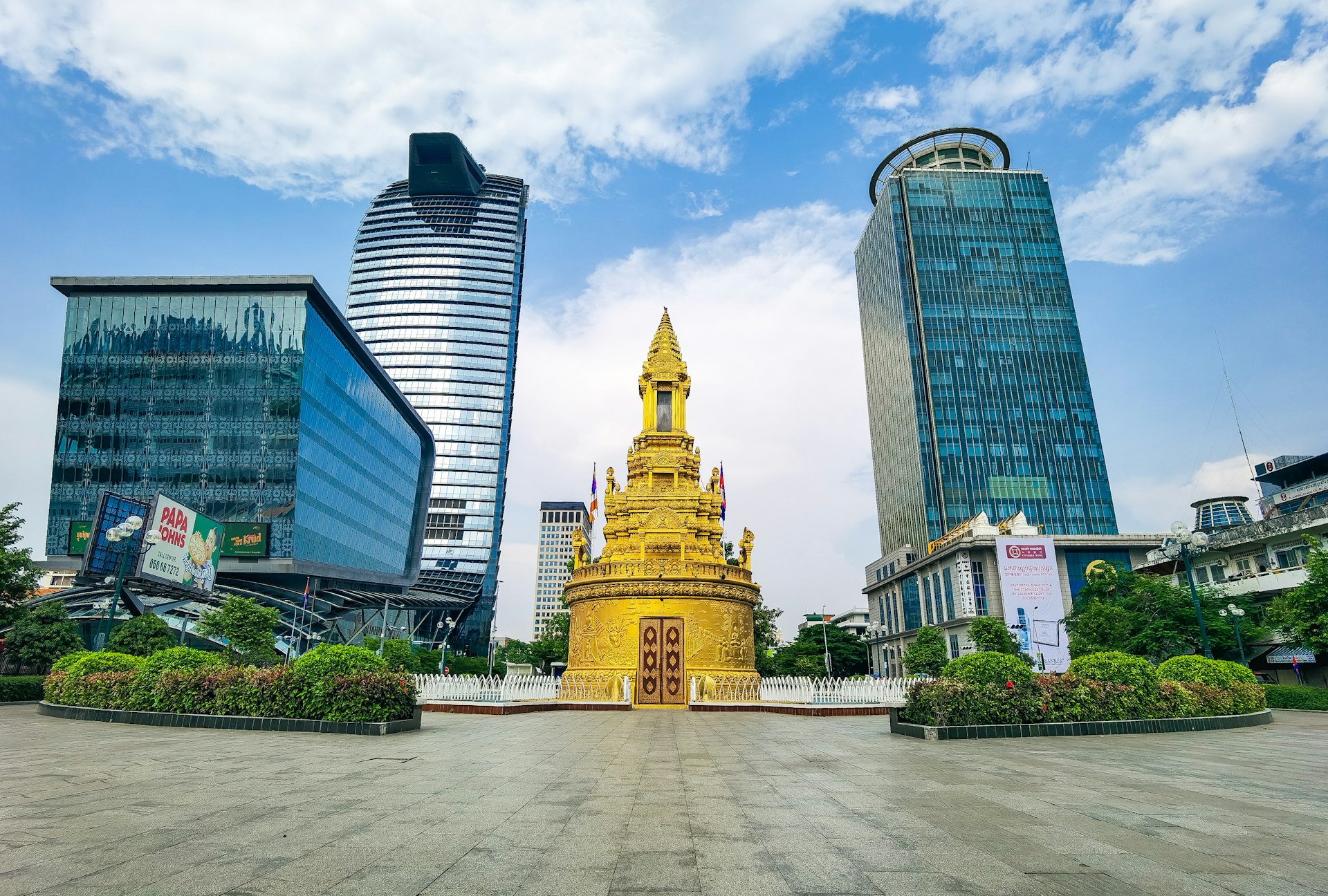 a large gold statue in front of a group of buildings